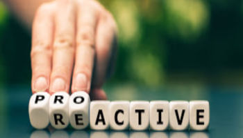 Hand turns dice and changes the word reactive to proactive.